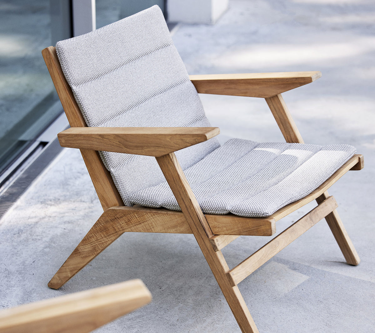 Stylish lounge chair with wooden frame and cushioned seat, designed for comfort and relaxation.