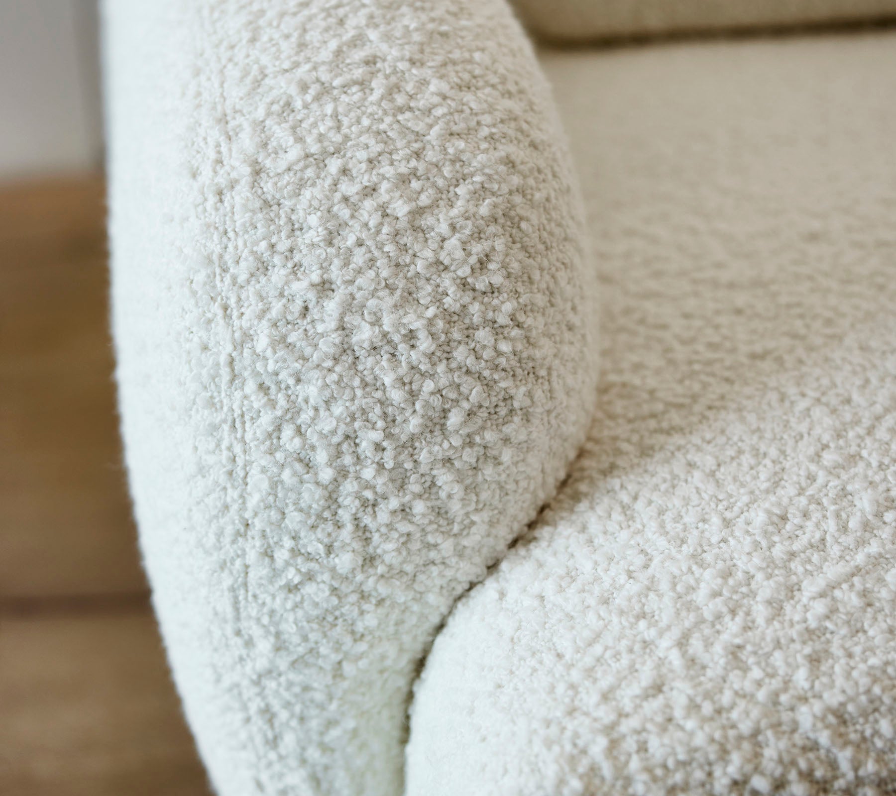 Close-up of a textured white sofa arm with a soft, fuzzy surface, adding a cozy and inviting aesthetic to any space.