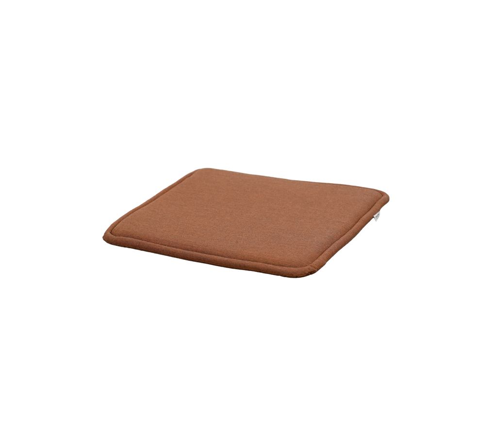 Desert red cushion with a square shape and subtle thickness.