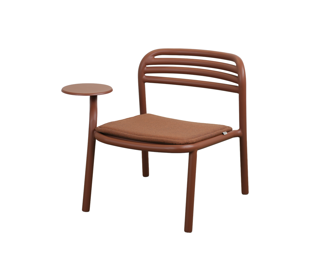 Modern chair in desert red with a small side table.