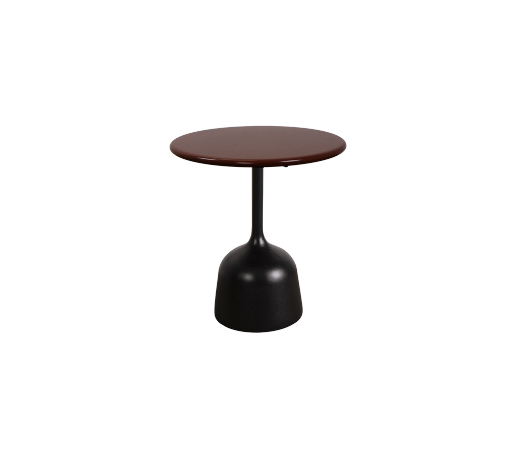 Modern burgundy table with a black base in a lounge setting.