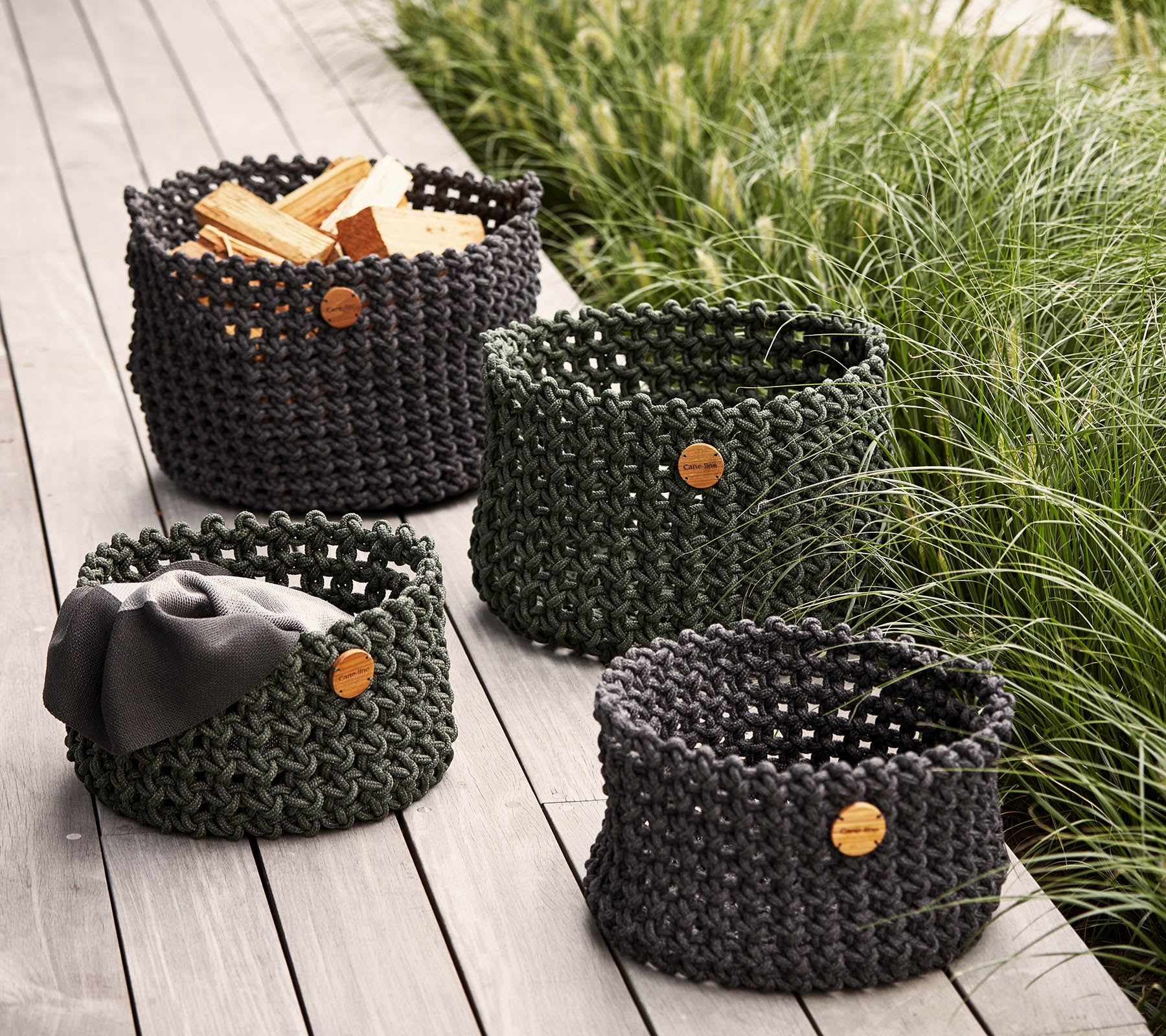 Set of four woven storage baskets in varying sizes, featuring natural wood labels, ideal for organizing and decorating.