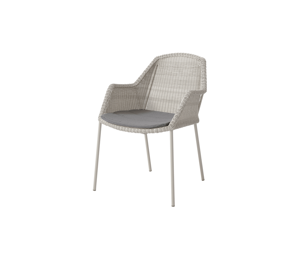 Chair with grey cushion in a light color.