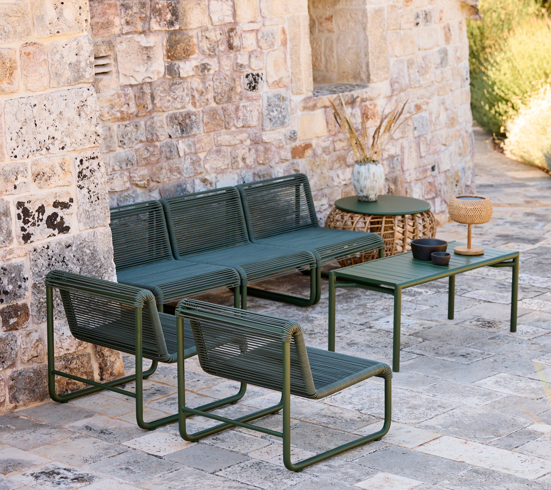 Modern green sofa and chairs with a matching table in a casual lounge setting.