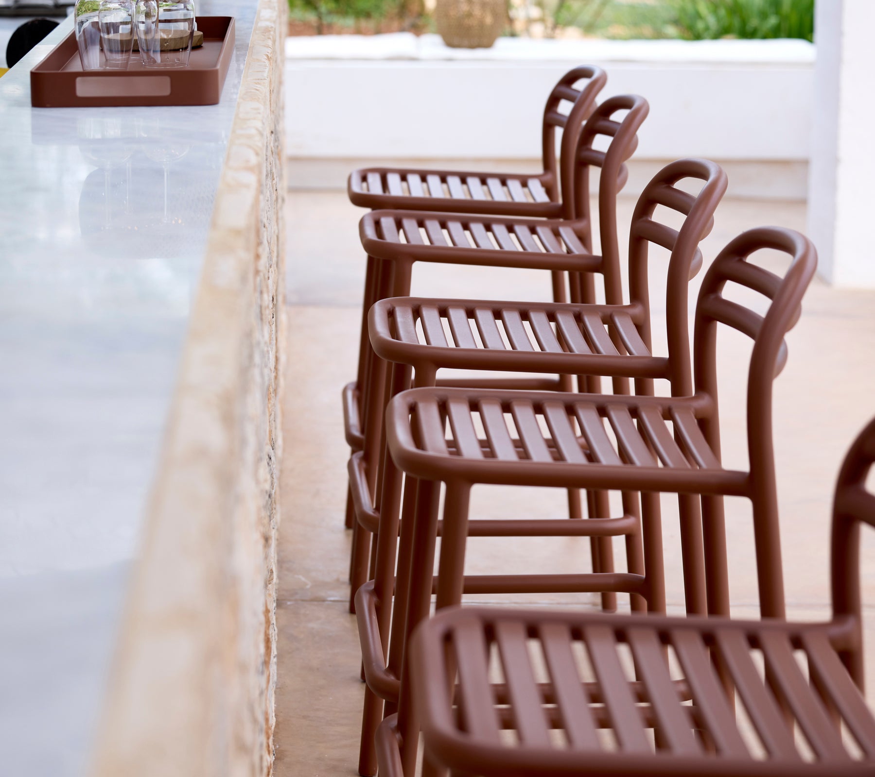 Row of brown bar stools lined up against a white bar countertop.