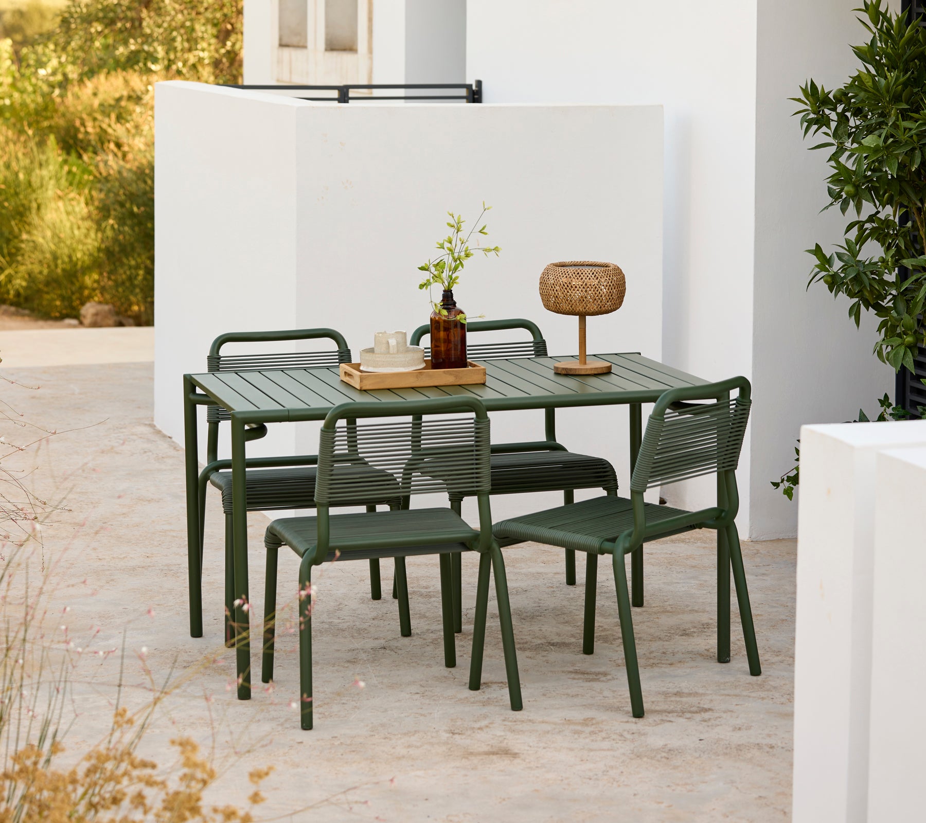 Modern green table with matching chairs set in an outdoor environment.
