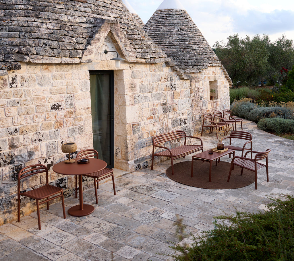 Outdoor setting with a brown table and chairs in a modern design.