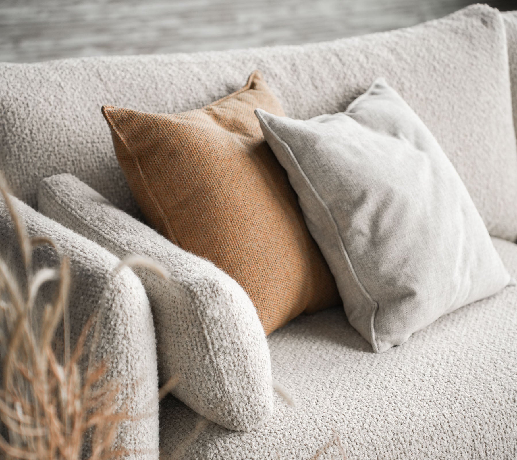Cozy couch featuring Bloom in sand color with two cushions, one in beige and the other in warm brown, adding a stylish touch.