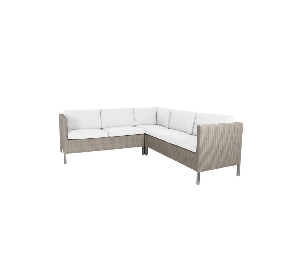 Stylish corner seating with a light-hued cushion and woven exterior, perfect for casual gatherings.
