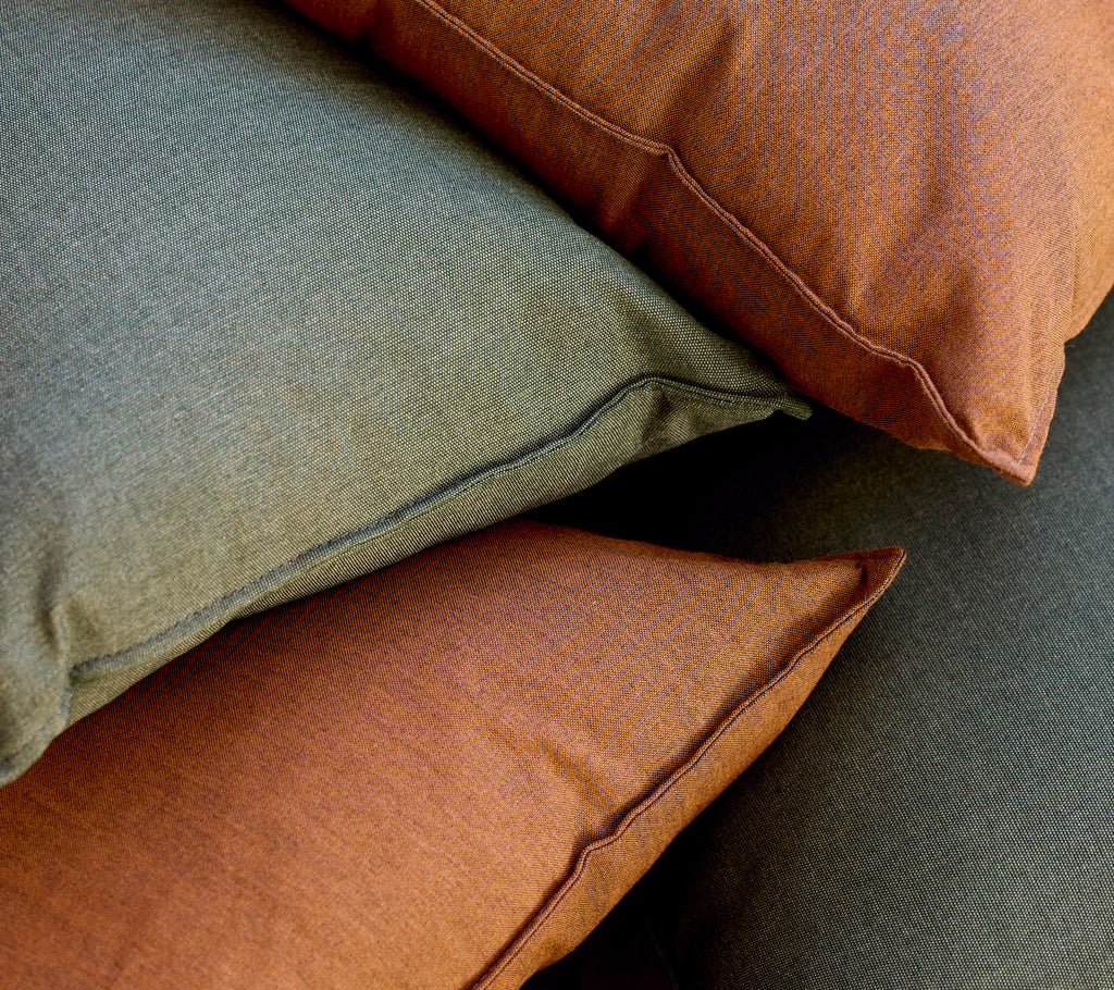 Stack of green and brown cushions arranged together.