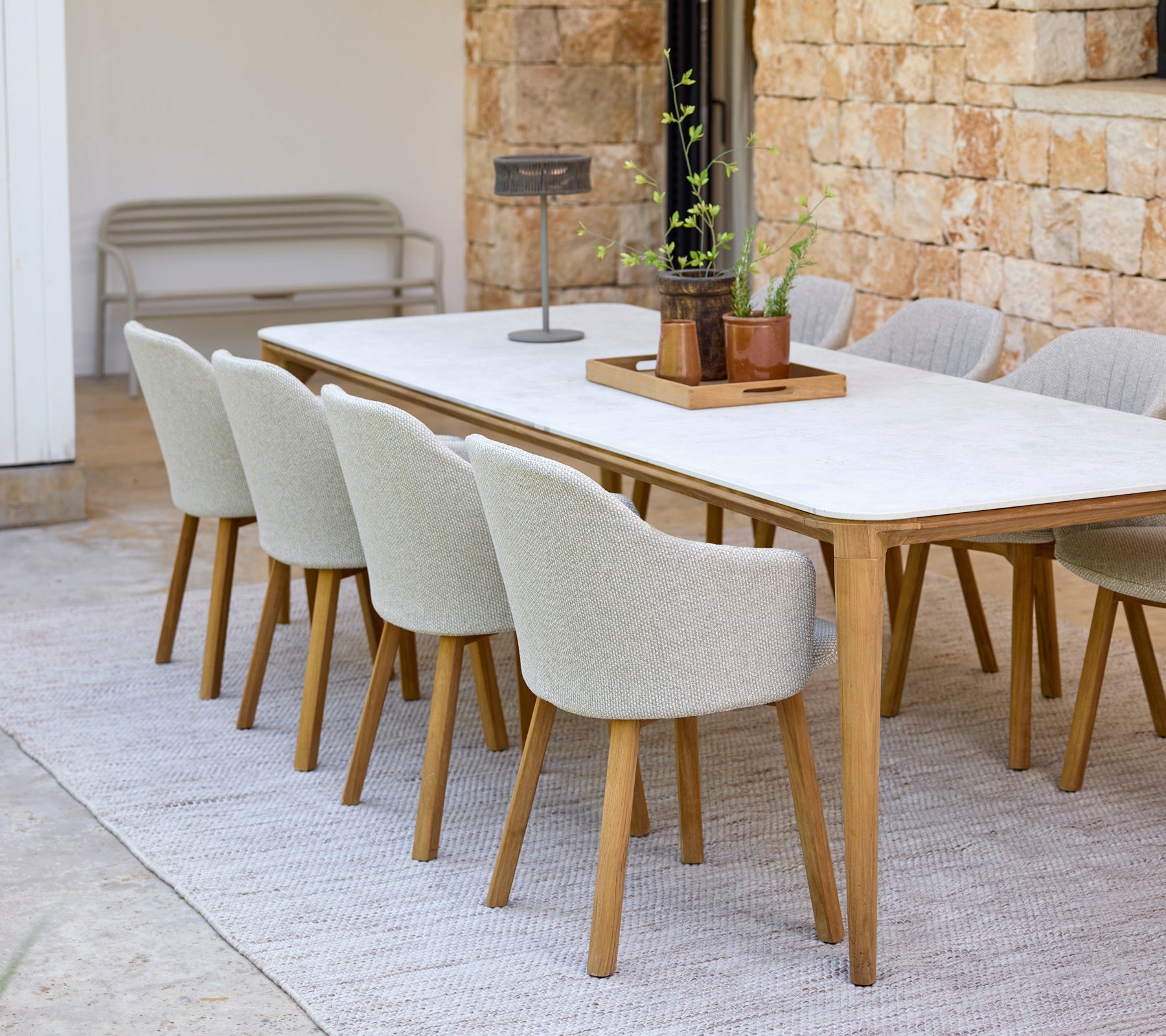 Modern dining setup with a white table and beige chairs.