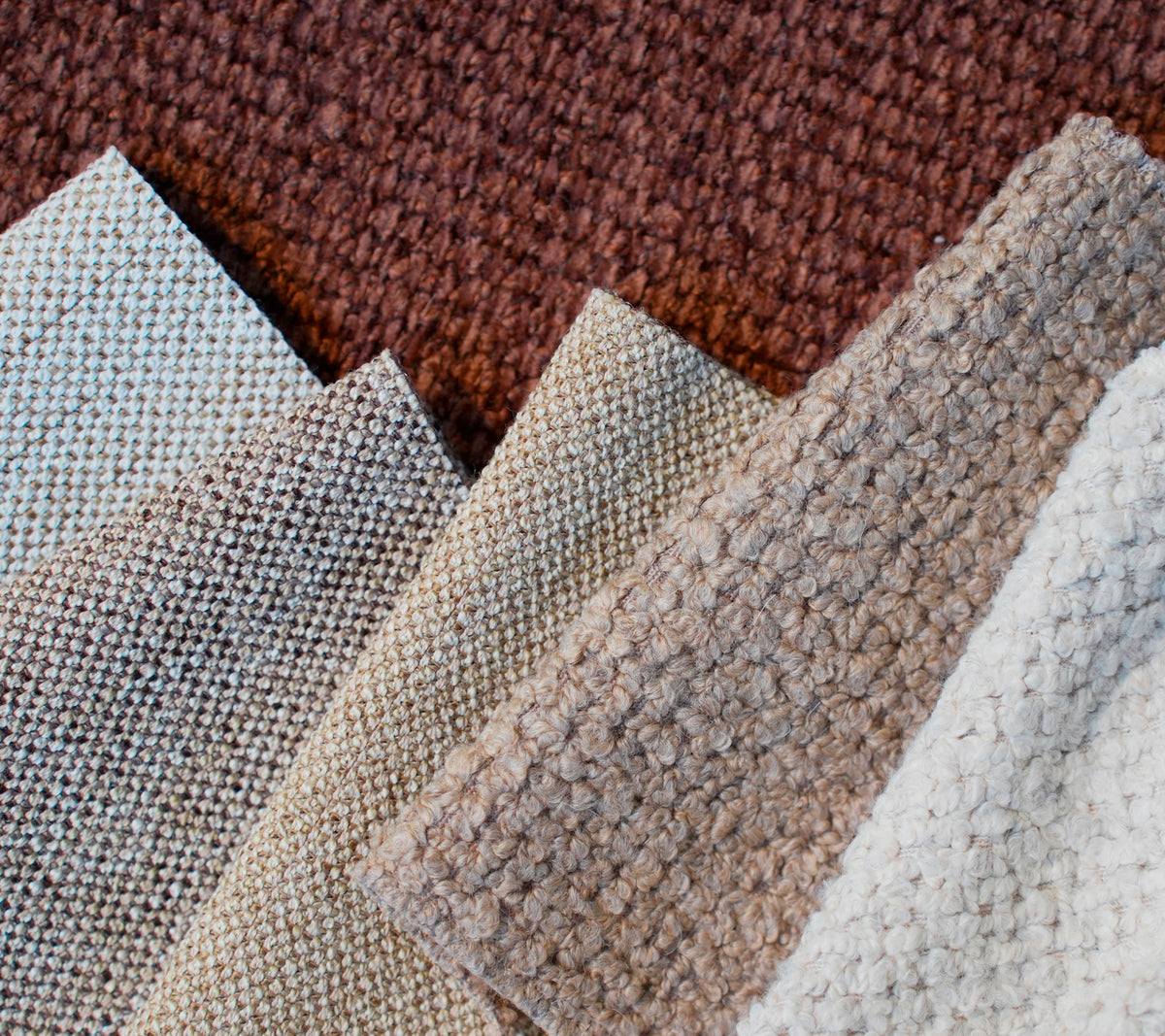 Swatches of various textured fabrics in brown, beige, light grey, and white.