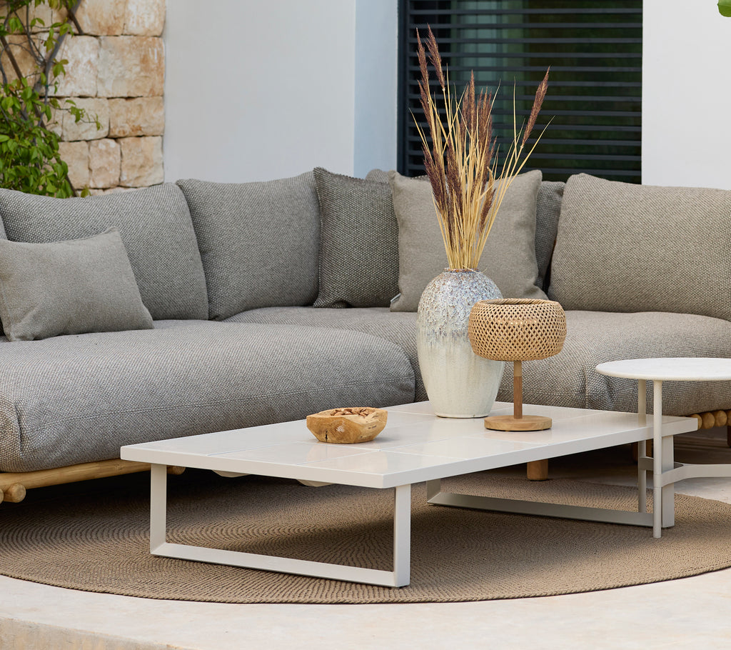 Modern lounge area featuring a grey sofa and a white coffee table with decor.