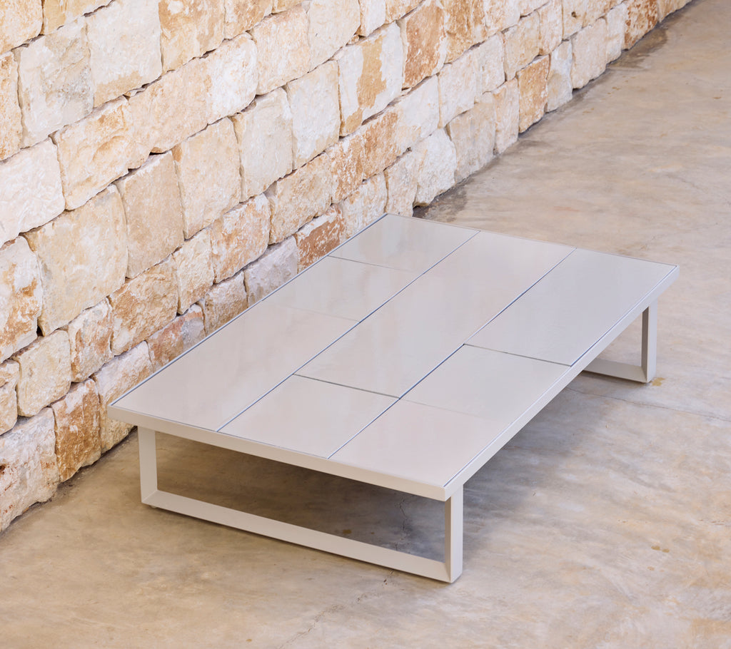 Modern grey coffee table with a minimalist design in a natural setting.