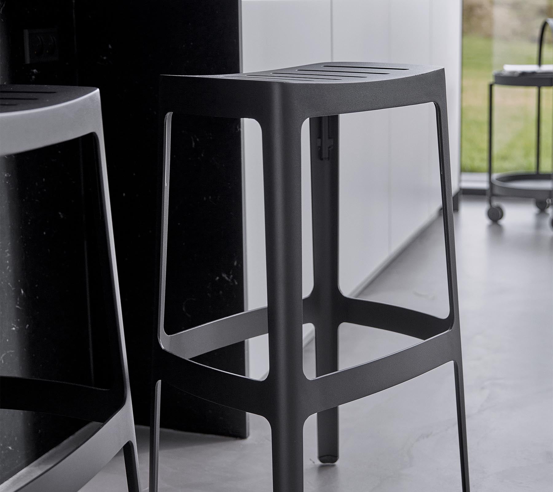 A sleek, modern barstool with a minimalist design, featuring a sturdy structure and an elegant black finish.