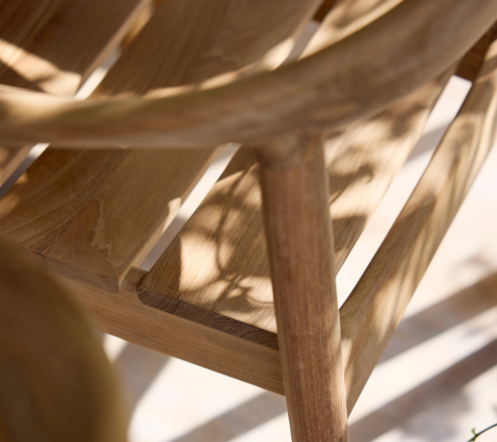 Close-up of a wooden chair highlighting its slatted design and natural finish.