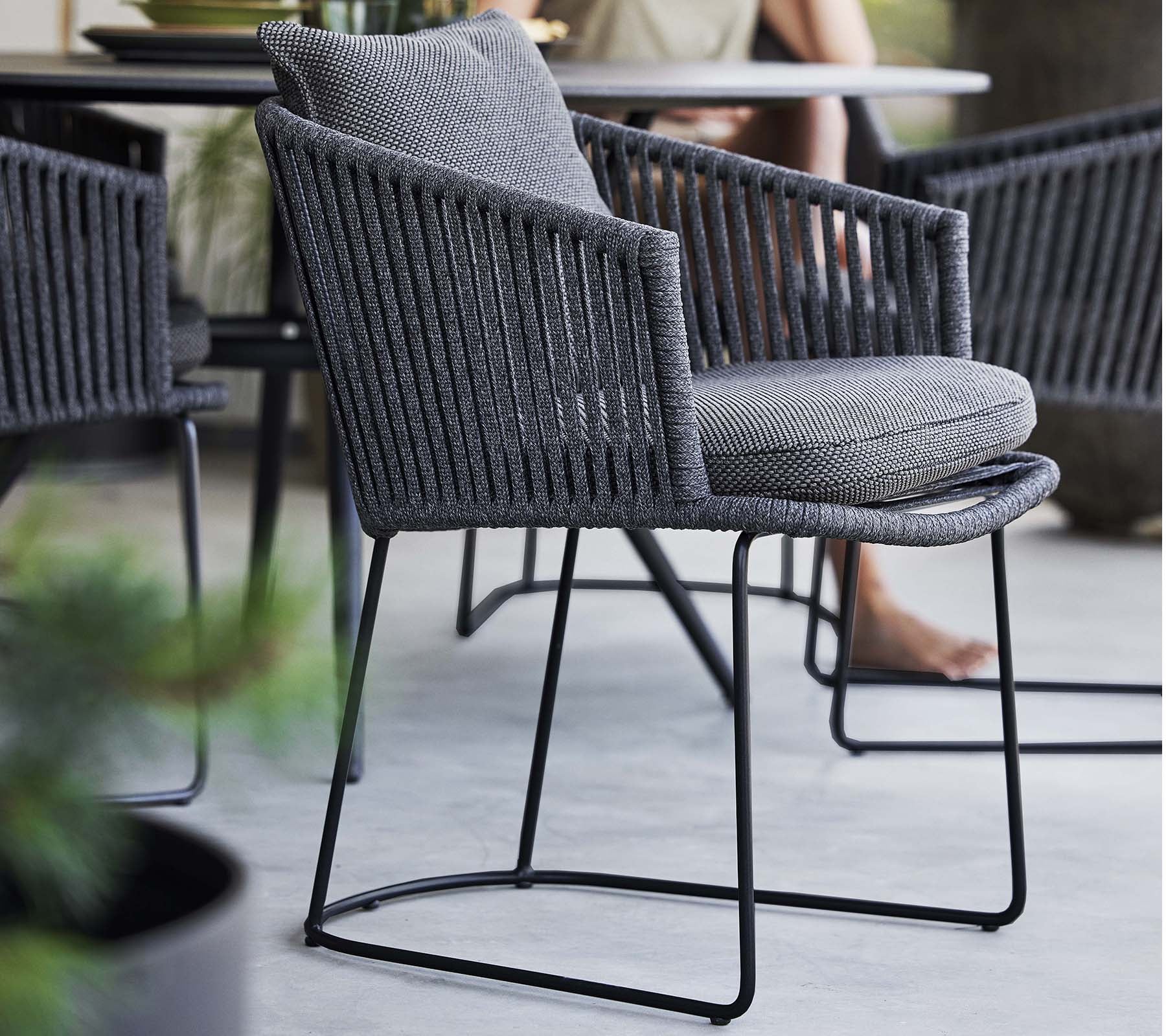 Stylish chair with a woven design and soft cushion, supported by a sleek metal frame, perfect for contemporary spaces.