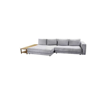 A modern, gray sectional sofa featuring plush cushions and a sleek wooden accent table on one side.